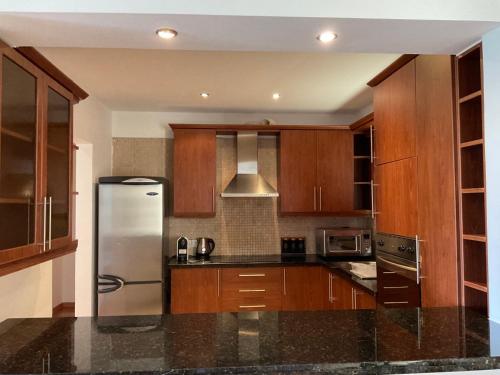 尼科西亚StayCity Flat!!!的厨房配有木制橱柜和不锈钢冰箱。
