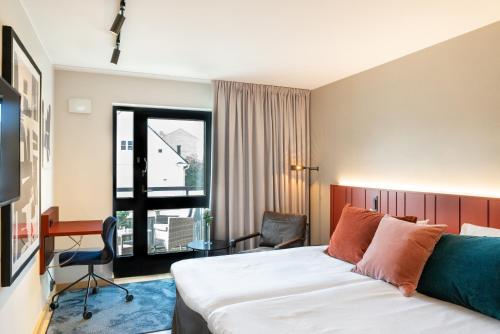 卡尔斯克鲁纳克拉丽奥卡尔斯科罗拉连锁酒店的配有一张床、一张书桌和一扇窗户的酒店客房