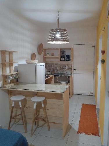 巴伊亚福尔莫萨Formosinha的厨房配有带冰箱和2张凳子的台面