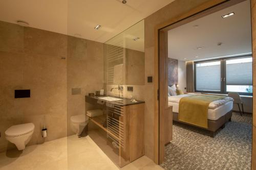 圣维特Ohles Lifestyle Guesthouse的一间卧室配有一张床,浴室设有卫生间