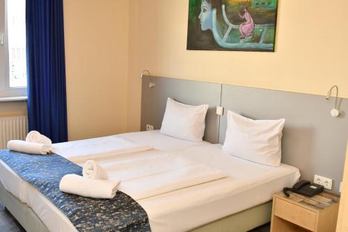 美因河畔法兰克福 慕尼黑霍夫酒店的卧室配有一张带白色床单和枕头的大床。