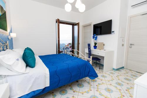 阿杰罗拉Panariello Palace的一间卧室配有蓝色的床和一张书桌
