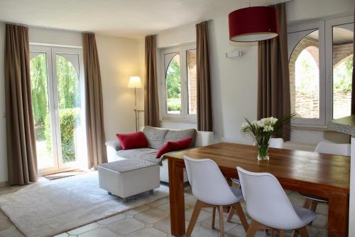 BierbeekB Apartment的客厅配有木桌和白色椅子