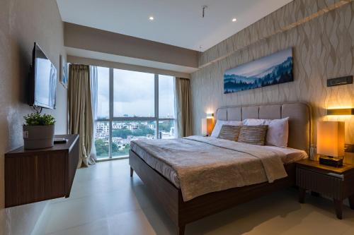 浦那AR Suites Jewels Royale - Koregaon Park NX的一间卧室设有一张大床和一个大窗户