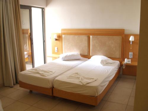 科斯镇圣君士坦丁公寓式酒店的一间卧室配有一张带白色床单的大床