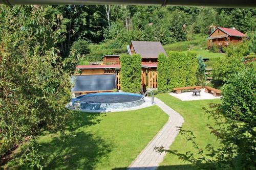 乌帕河畔斯沃博达Chata U lesa的一个带游泳池和房子的后院