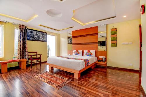 科代卡纳尔FabHotel Abirami Grand Inn的一间卧室配有一张床,铺有木地板