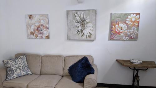 圣胡安圣胡安老船长公寓的客厅配有沙发,墙上有三幅画作