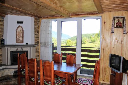 亚列姆切Cottage "Karpatske Shale"的一间带桌椅和电视的用餐室