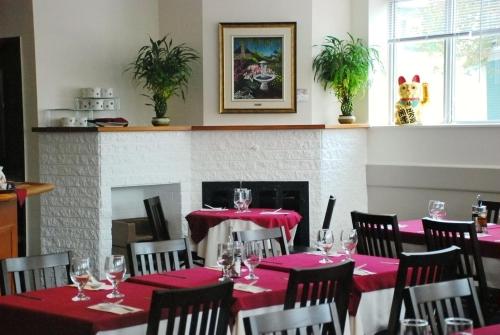 梅戈格格兰湖滨酒店的一间用餐室,配有红色的桌椅和壁炉
