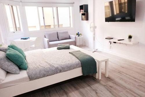 大加那利岛拉斯帕尔马斯Precioso apartamento a 150 metros de la Playa的白色卧室配有床和椅子