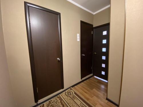 赤塔Dekabrist apartment at Ugdanskaya 8的一条空的走廊,有两扇门,有地毯