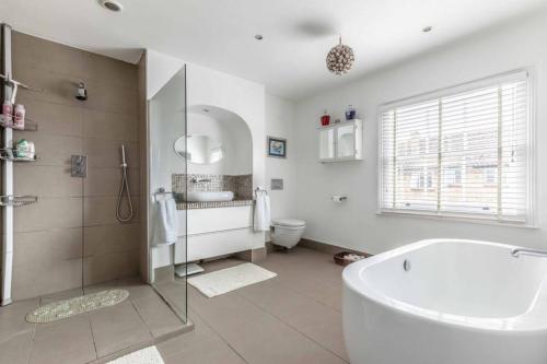 温莎Windsor Town Centre Victorian townhouse sleeps 6的带浴缸、盥洗盆和卫生间的浴室