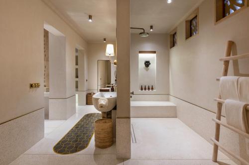 萨三吉尔Aramness Gir National Park的浴室配有卫生间、盥洗盆和浴缸。