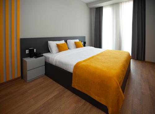 第比利斯Old City Boutique Hotel的一间卧室配有一张大床,床上有黄色的毯子