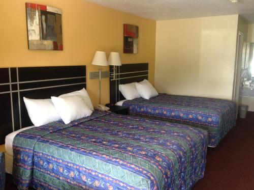 霍顿Countryside Inn的酒店客房设有两张床和两盏灯。