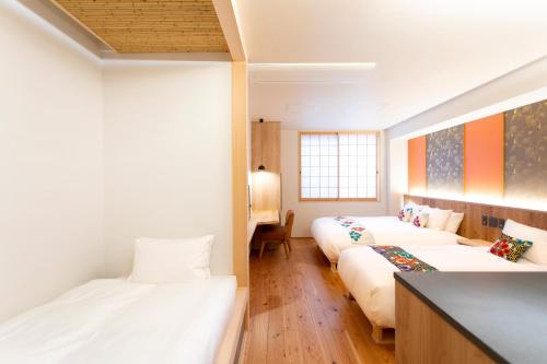 金泽Hotel Kanazawa Zoushi的一间客房配有两张床和一张沙发