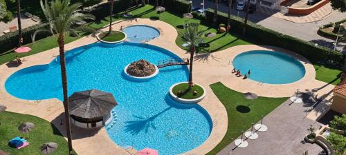 库列拉Apartamentos Florazar II的享有2个带遮阳伞的游泳池的顶部景致