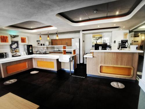 布隆方丹SUN1 BLOEMFONTEIN的厨房配有白色的柜台和橙色的点缀