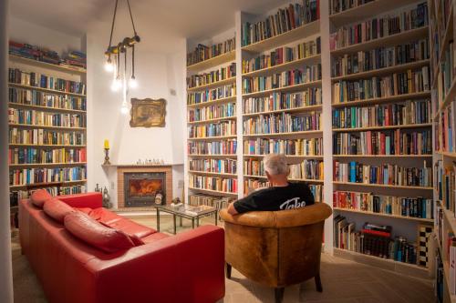 孔佩塔Malaga Hills Double Comfort Boutique & Wellness Hotel -Adults Only-的坐在图书馆椅子上的男人