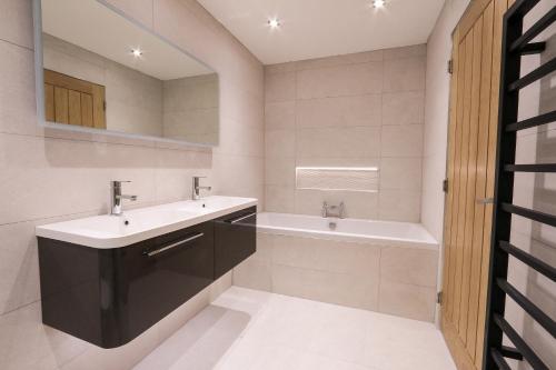 布罗德福德Black Barn Skye - Contemporary 3 bed / 4 bath home的浴室配有盥洗盆和浴缸。