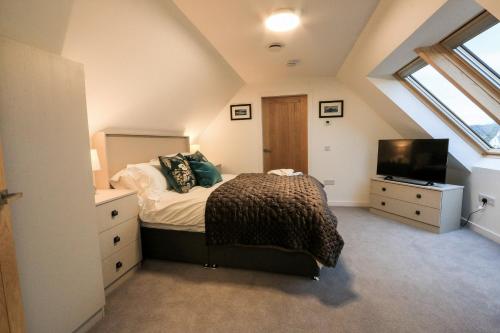 布罗德福德Black Barn Skye - Contemporary 3 bed / 4 bath home的阁楼卧室配有1张床和电视