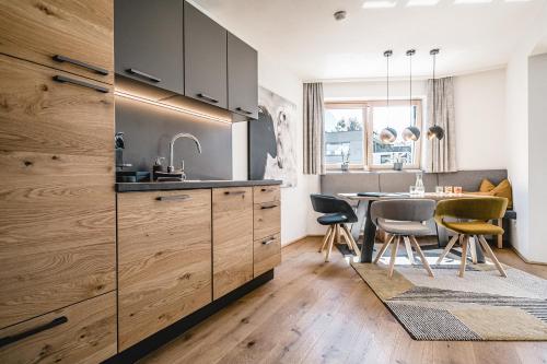 佩尔蒂绍Cabin8 Alpine Flair Apartments的厨房配有木制橱柜和桌椅