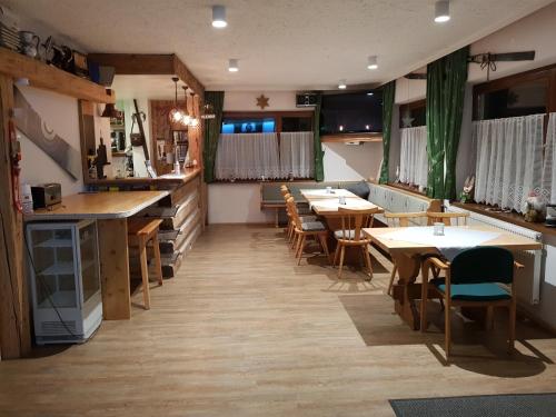 MörtschachTattoo PENSION mit Restaurant und Tattoo-Studio的一间在房间内配有桌椅的餐厅
