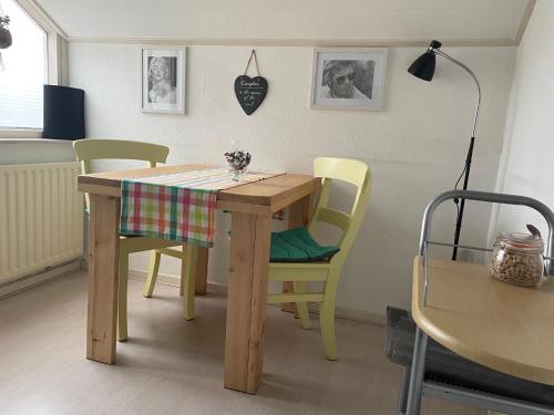斯哈亨De Spiegel的餐桌、两把椅子、一张桌子和一张桌布