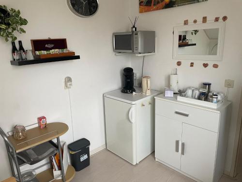 斯哈亨De Spiegel的厨房配有白色冰箱和桌子