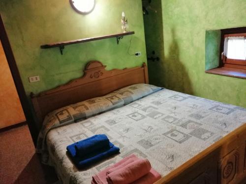 多莫多索拉Casa vacanze La Carbunera的绿色客房内的一张床位,上面有两条毛巾