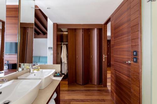 卡拉马塔Horizon Blu Boutique Hotel的一间带两个水槽和木门的浴室