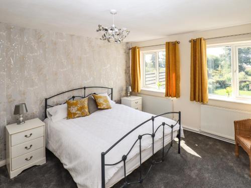 奥姆斯柯克8 Heatons Bridge Road的一间卧室设有一张床和两个窗户。