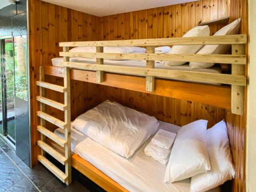 LochalineHighland Basecamp的客房设有2张双层床和白色枕头。