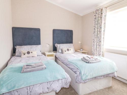 格兰瑟姆Stonesthrow的卧室设有两张蓝色和白色的床