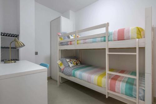曼雷沙Apartamento ideal en Manresa的白色的客房设有两张双层床和一张书桌