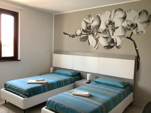 阿佐诺圣保罗VILLAFIORE的墙上画画的房间里设有两张床