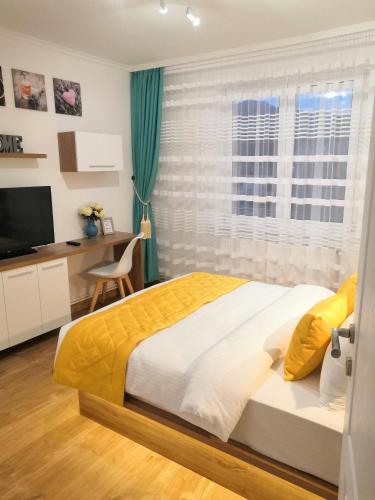 布拉索夫ONYX - Utopia Aparthotel的一间卧室配有一张床、一张书桌和一个窗户。