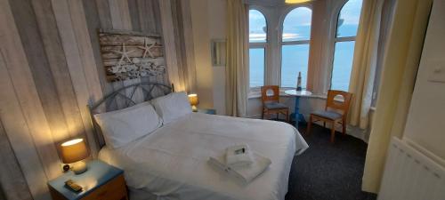 布莱克浦Bowies Lodge的酒店客房带一张床、一张桌子和窗户