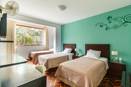 皮乌拉Posada Blanca Hotel Boutique的酒店客房设有两张床和窗户。
