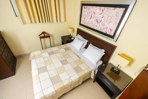 皮乌拉Posada Blanca Hotel Boutique的小卧室配有一张带 ⁇ 子毯子的床