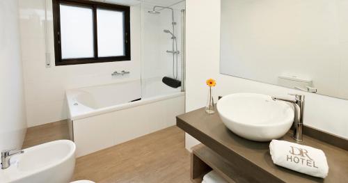 艾因萨Hotel Dos Rios Central的白色的浴室设有水槽和浴缸。