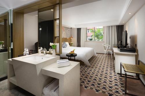 广州Paco Hotel Gangding Metro Guangzhou的一间带水槽的浴室和一张位于客房内的床