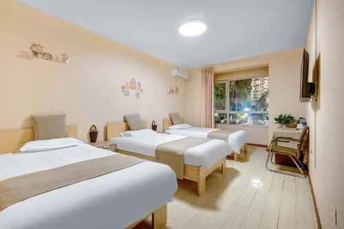 哈尔滨哈尔滨哈什国际青年旅舍哈尔滨西站店的一间医院房间,设有四张床和窗户