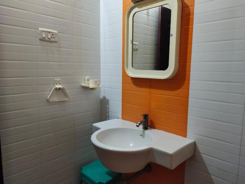 杜蒂戈林Hotel Geetha International的浴室设有白色水槽和镜子