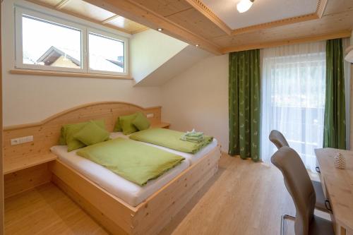 海利根布卢特Zirbenchalet Grossglockner的一间卧室配有一张带绿色枕头的床和一扇窗户