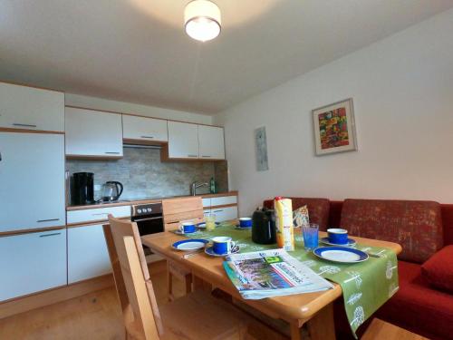 AltenstadtFerienwohnung Vroni的小厨房配有桌子、沙发、桌子和椅子