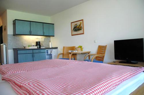 Neu KlockenhagenFerienwohnung "Greifswald"的一间卧室配有一张带红白毯子的床