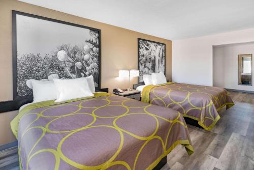 阿马里洛西阿马里洛速8酒店的酒店客房设有两张床,墙上挂有绘画作品
