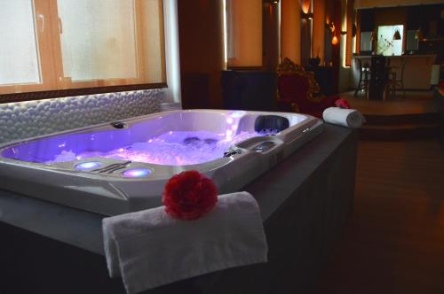 韦尔维耶Le BELLEA的红花酒店客房内的按摩浴缸